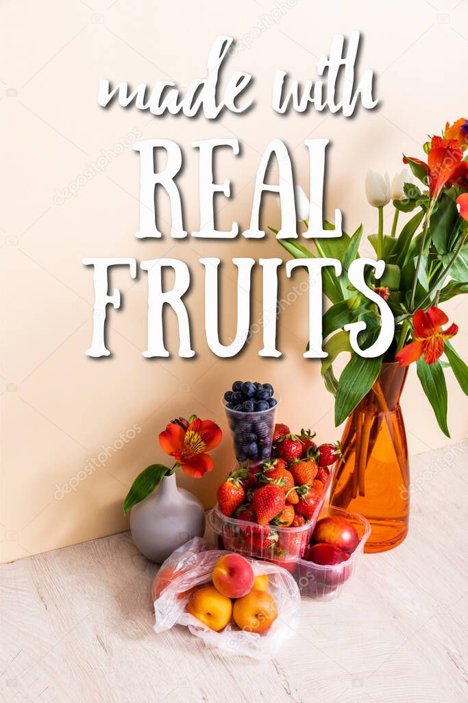 floral composition with flowers in vases near fruits and made with real fruits lettering on beige 
