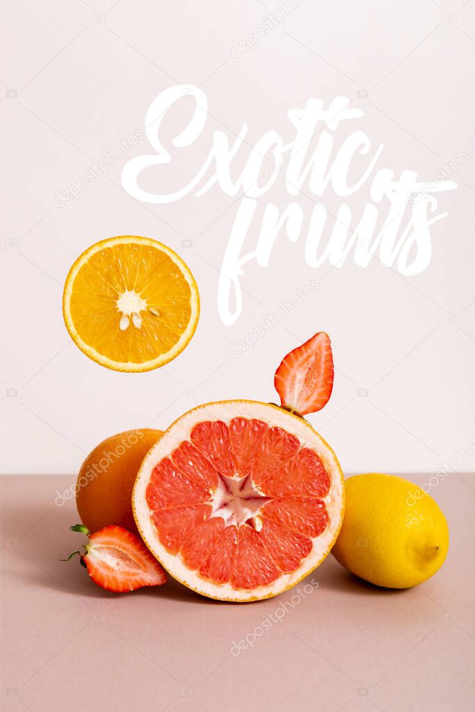 fruit composition with citrus fruits and strawberry near exotic fruits lettering on beige