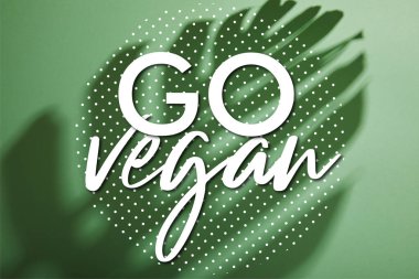 Yeşil arka planda tropikal yaprak gölgesi ve vegan çizimi