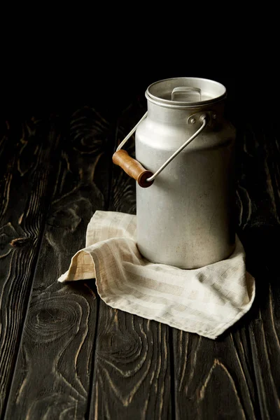 Imagen de primer plano de la leche en lata de aluminio sobre tela de saco sobre fondo negro - foto de stock
