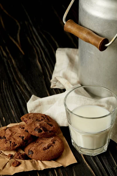 Biscoitos de chocolate, leite em vidro e lata de alumínio em pano de saco — Fotografia de Stock