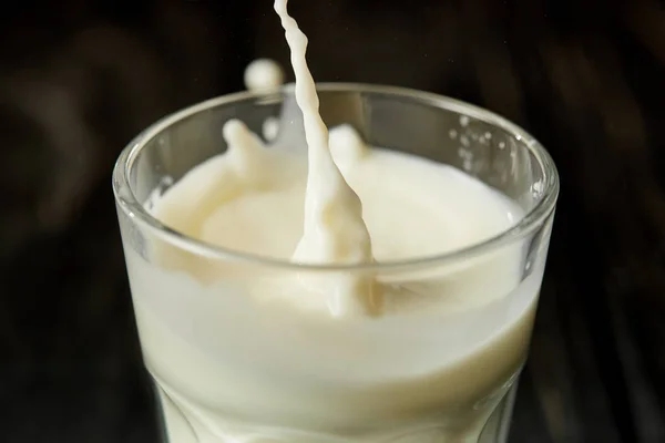 Vista de cerca de gotas salpicaduras de leche de vidrio - foto de stock