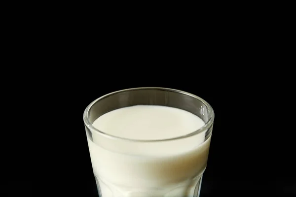 Vue rapprochée du verre de lait isolé sur fond noir — Photo de stock