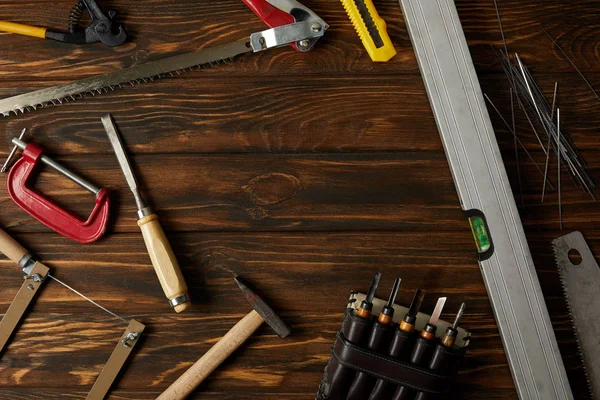 Elevated view of different tools on brown wooden tabletop — Stock Photo