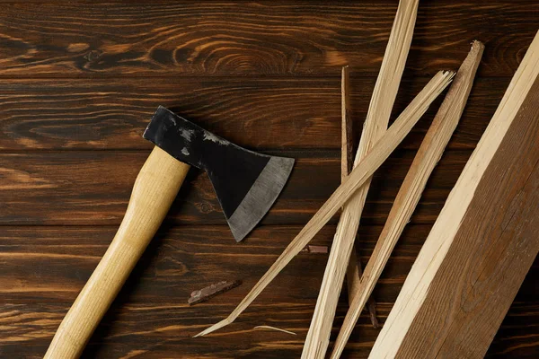 Top view of axe and wooden pieces on brown table — Stock Photo