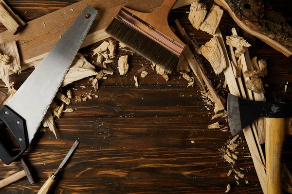 Vista elevada de diferentes herramientas y piezas de madera en la mesa - foto de stock