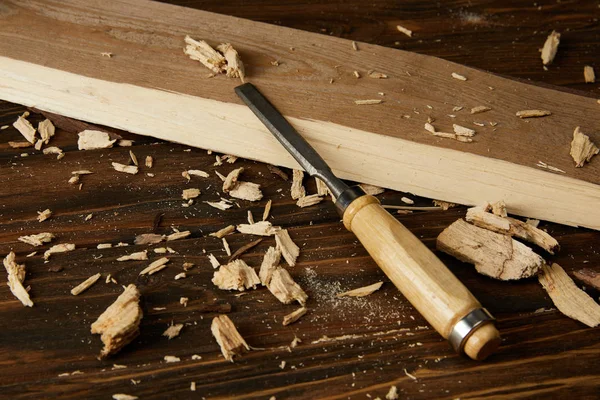 Vue rapprochée de la planche et des pièces en bois avec ciseau sur table brune — Photo de stock