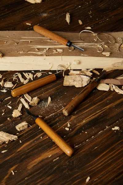 Gros plan de ciseaux et de morceaux de bois sur une table brune — Photo de stock