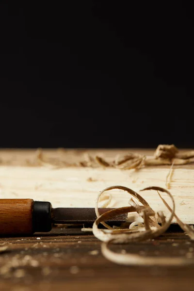 Closeup shot of wooden pieces and chisel on brown table — Stock Photo