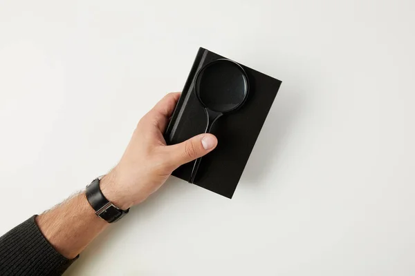 Cropped shot of person holding notebook and magnifying glass isolated on white — Stock Photo