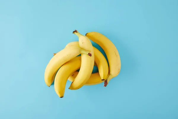 Vue de dessus des bananes fraîches disposées isolées sur bleu — Photo de stock