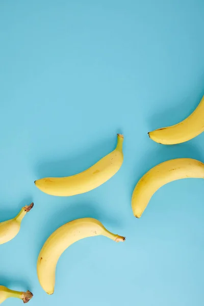Вид сверху на упорядоченные свежие бананы, изолированные на голубом — стоковое фото