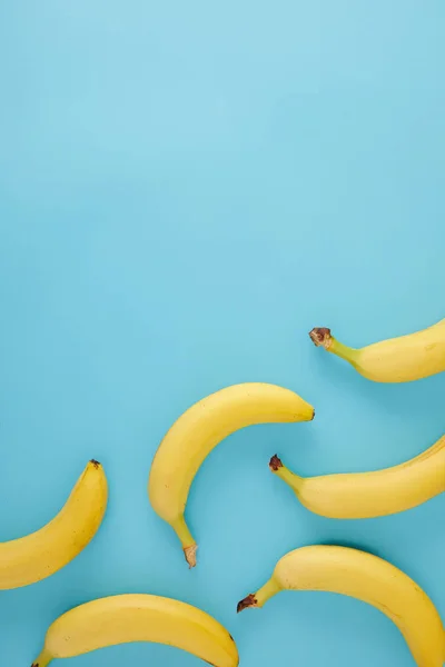 Вид сверху на упорядоченные свежие бананы, изолированные на голубом — стоковое фото