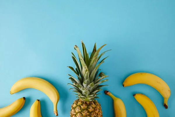 Flat lay com bananas frescas e abacaxi isolado em azul — Fotografia de Stock