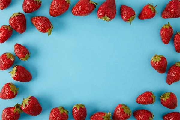 Vista superior de fresas frescas dispuestas aisladas en azul - foto de stock