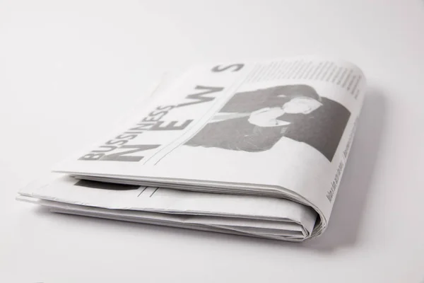 Close up of pile of business newspapers, on white — Stock Photo