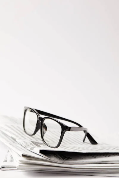 Nahaufnahme von Zeitungen mit schwarzer Brille, auf weiß mit Kopierraum — Stockfoto