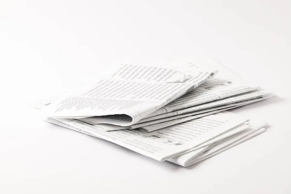 Heap of black and white newspapers, isolated on white — Stock Photo