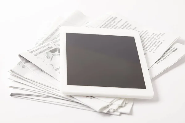 Nahaufnahme eines Zeitungsstapels mit digitalem Tablet, auf weiß — Stockfoto