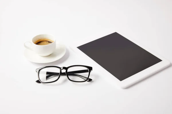 Taza de café, vasos y tableta digital con pantalla en blanco en la mesa blanca - foto de stock