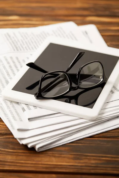 Gläser, Kaffeetasse, digitales Tablet und Zeitungspapier auf Holztisch — Stockfoto