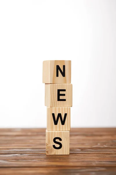 Cubos del alfabeto haciendo noticias de la palabra en la mesa de madera, en blanco - foto de stock