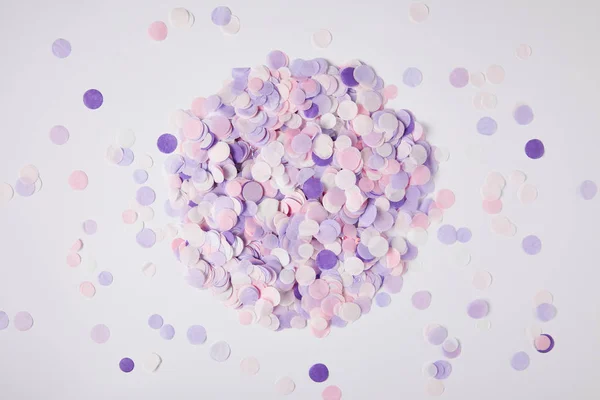 Draufsicht auf Haufen violetter Konfetti auf weißer Oberfläche — Stockfoto