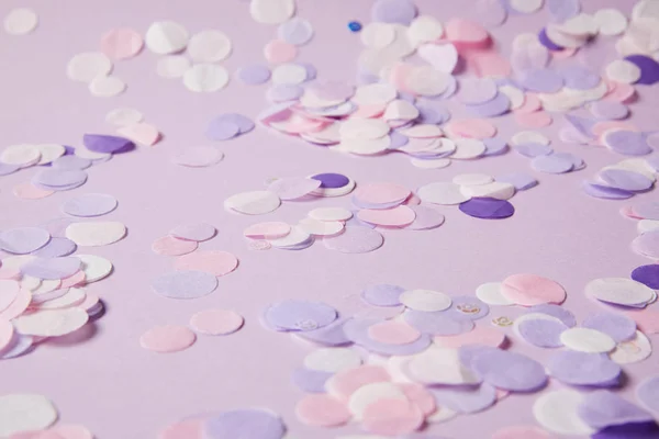Selective focus of confetti pieces on violet surface — Stock Photo