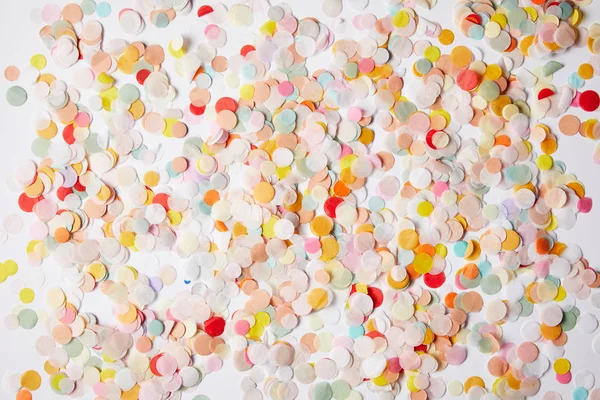 Top view of colored confetti pieces on white tabletop — Stock Photo