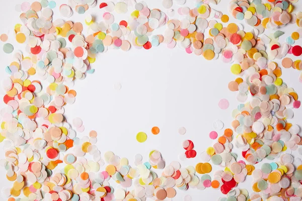 Vue de dessus des morceaux de confettis colorés sur la surface blanche — Photo de stock