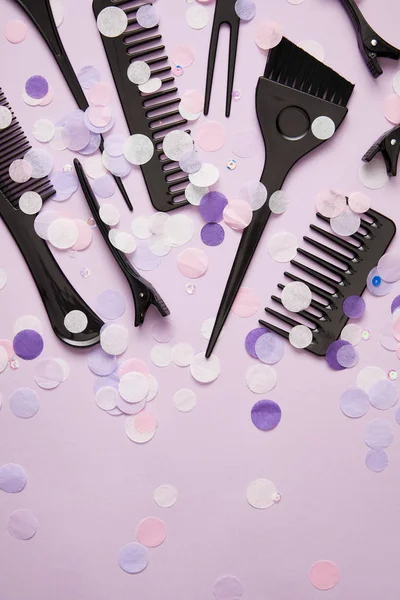 Top view of various tools for hairdressing and confetti on purple — Stock Photo