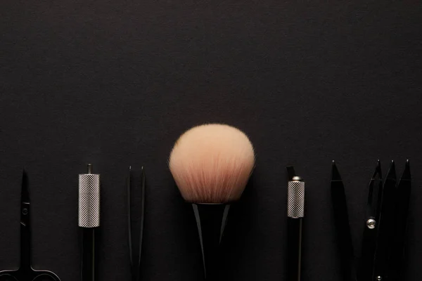 Primer plano de las herramientas para el maquillaje permanente aislado en negro - foto de stock