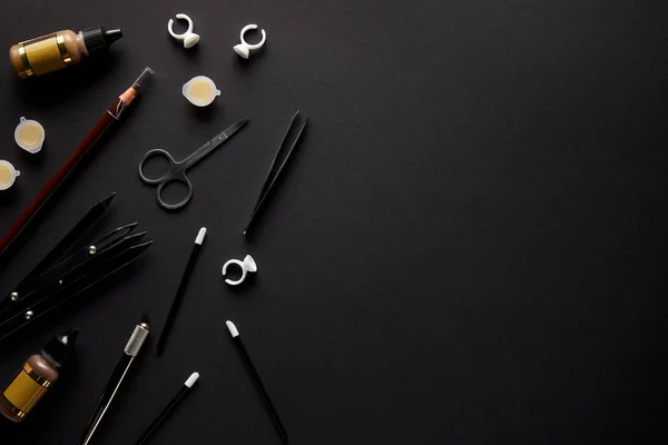 Elevated view of scissors, pencil and brushes for permanent makeup isolated on black — Stock Photo