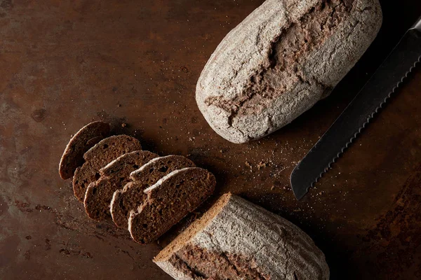 Top view of bread, slices and knife on rusty metal table — Stock Photo