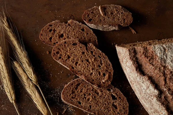 Vista superior de rebanadas de pan y trigo en la mesa de metal oxidado marrón - foto de stock
