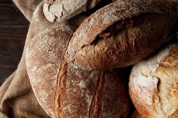 Vue de dessus de différents types de pain et sac sur table en bois — Photo de stock