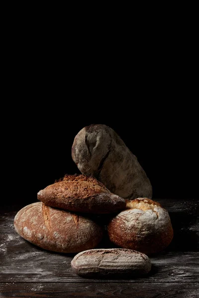 Close up image of various types of bread on wooden table covering by flour — Stock Photo