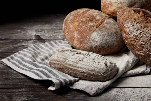 Image rapprochée de différents types de pain, farine et sac sur table en bois — Photo de stock
