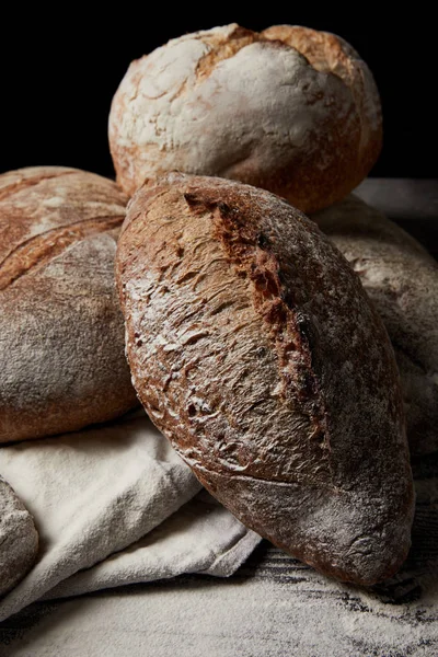 Nahaufnahme verschiedener Brotsorten, Mehl und Sacktuch auf Holztisch — Stockfoto