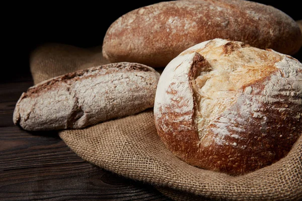 Закрыть изображение различных видов хлеба и мешковины на деревянном столе — стоковое фото