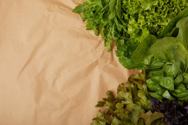 Draufsicht auf frisches Blattgemüse auf zerknülltem Papier — Stockfoto