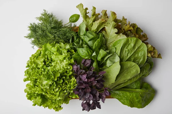 Вид сверху на различные спелые овощи из листьев в коробке на белой поверхности — стоковое фото