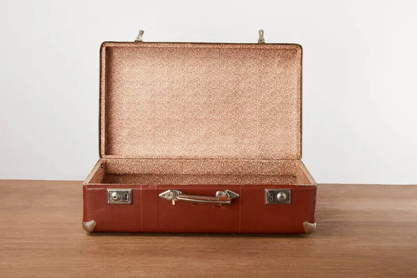 Открытый винтажный чемодан на деревянном столе — стоковое фото