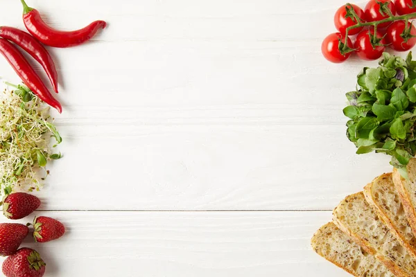 Vue de dessus des ingrédients pour un sandwich savoureux sur une surface en bois blanc — Photo de stock