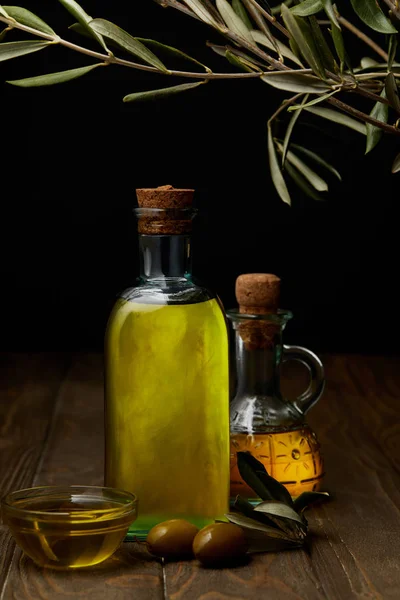 Bottles of various olive oil on wooden surface — Stock Photo