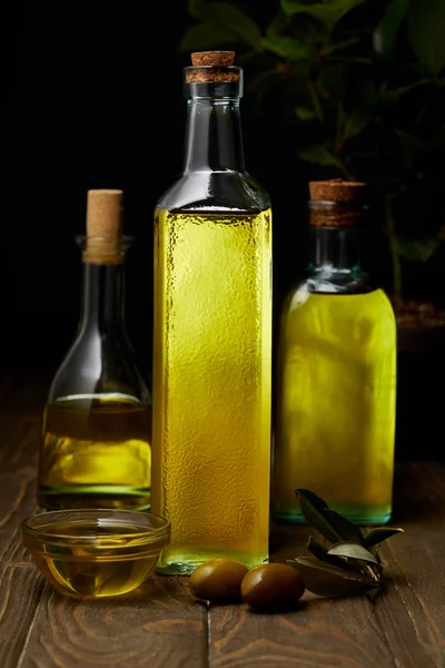 Bottles of various olive oil on wooden tabletop — Stock Photo