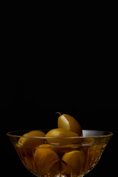 Olive in ciotola con olio isolato su nero — Foto stock