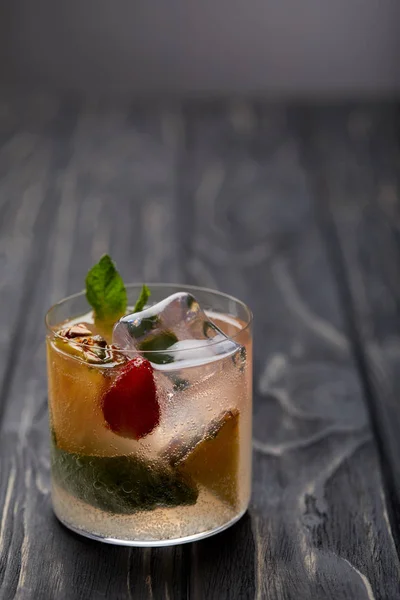 Vaso de limonada con cubitos de hielo, hojas de menta, trozos de piña y fresa - foto de stock