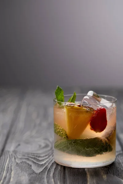 Vaso de limonada con cubitos de hielo, hojas de menta, piña y fresa - foto de stock