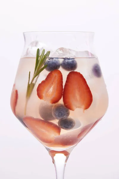 Glass of lemonade with rosemary, blueberries and strawberries isolated on white background — Stock Photo